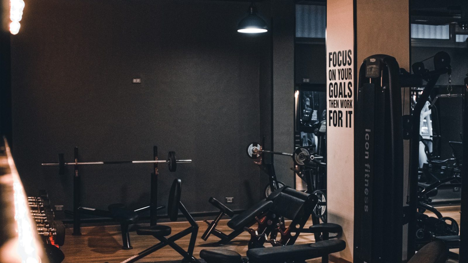 A dark training floor with benches and racks